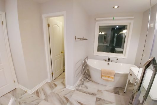 Condo master bathroom renovation with freestanding bathtub