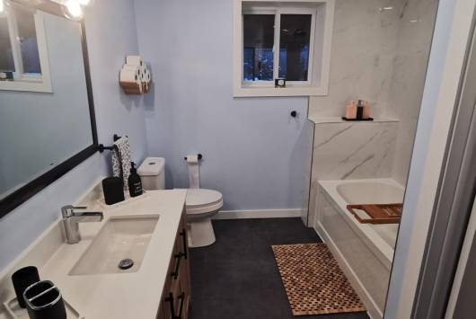Custom bathroom remodel in Ottawa with brown vanity and wall mirror