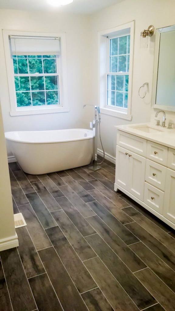 bathroom renovation with freestanding tub and warm wood finishes