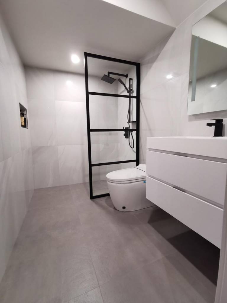 Bathroom with freestanding vanity, walk-in shower, and tile floors, showcasing modern bathroom design trends