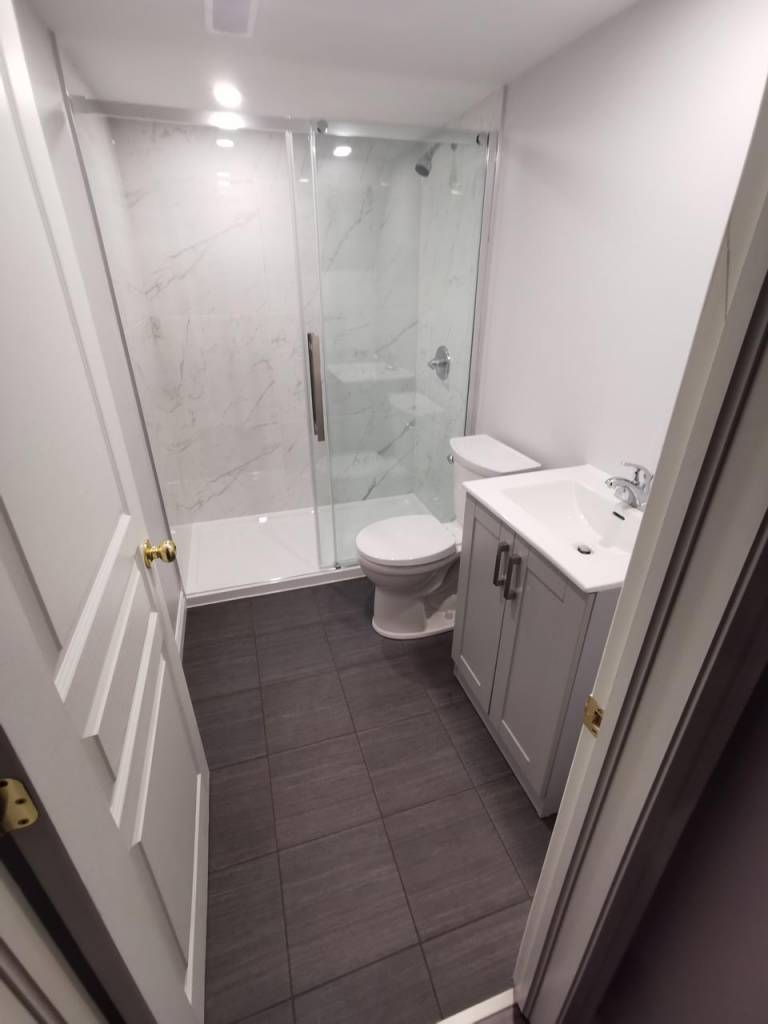 Small bathroom with silver fixtures and black tile floors