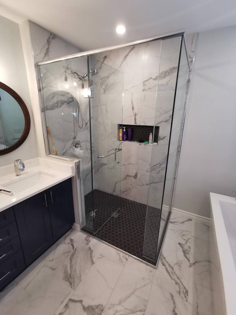 Compact walk-in shower with white tile and black fixtures